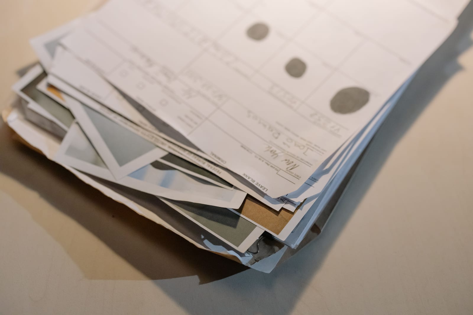 A thick, worn stack of paper report forms piled on a desk
