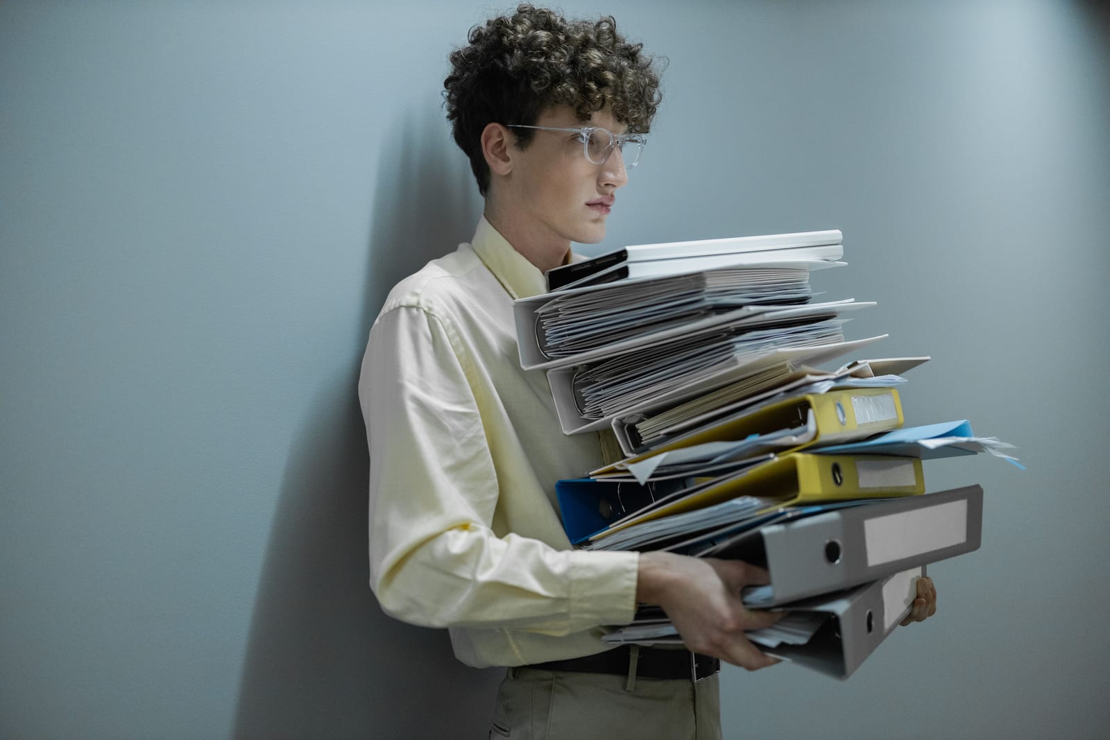Worker carrying a tall stack of binders