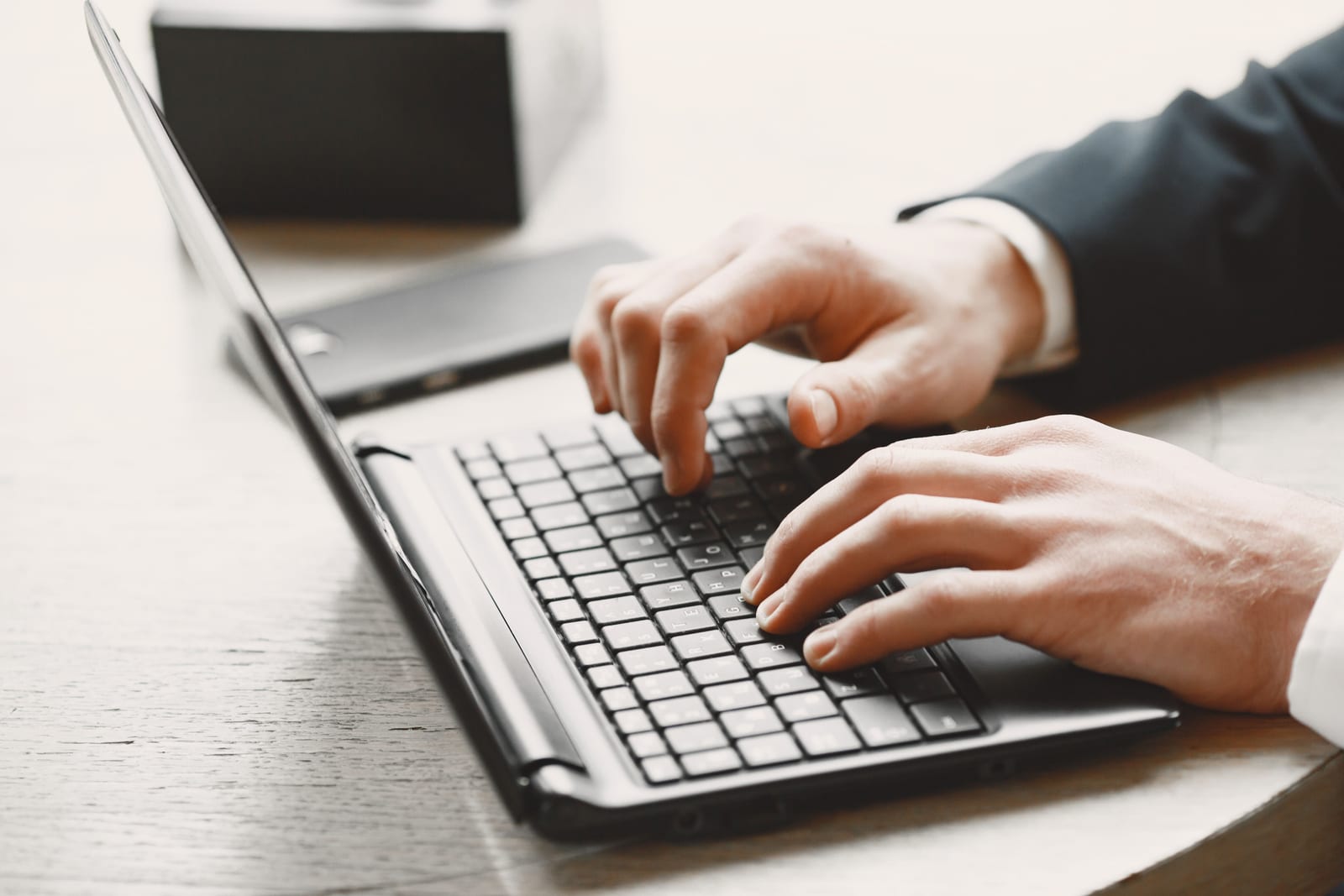 A clinician's hands typing at a laptop keyboard