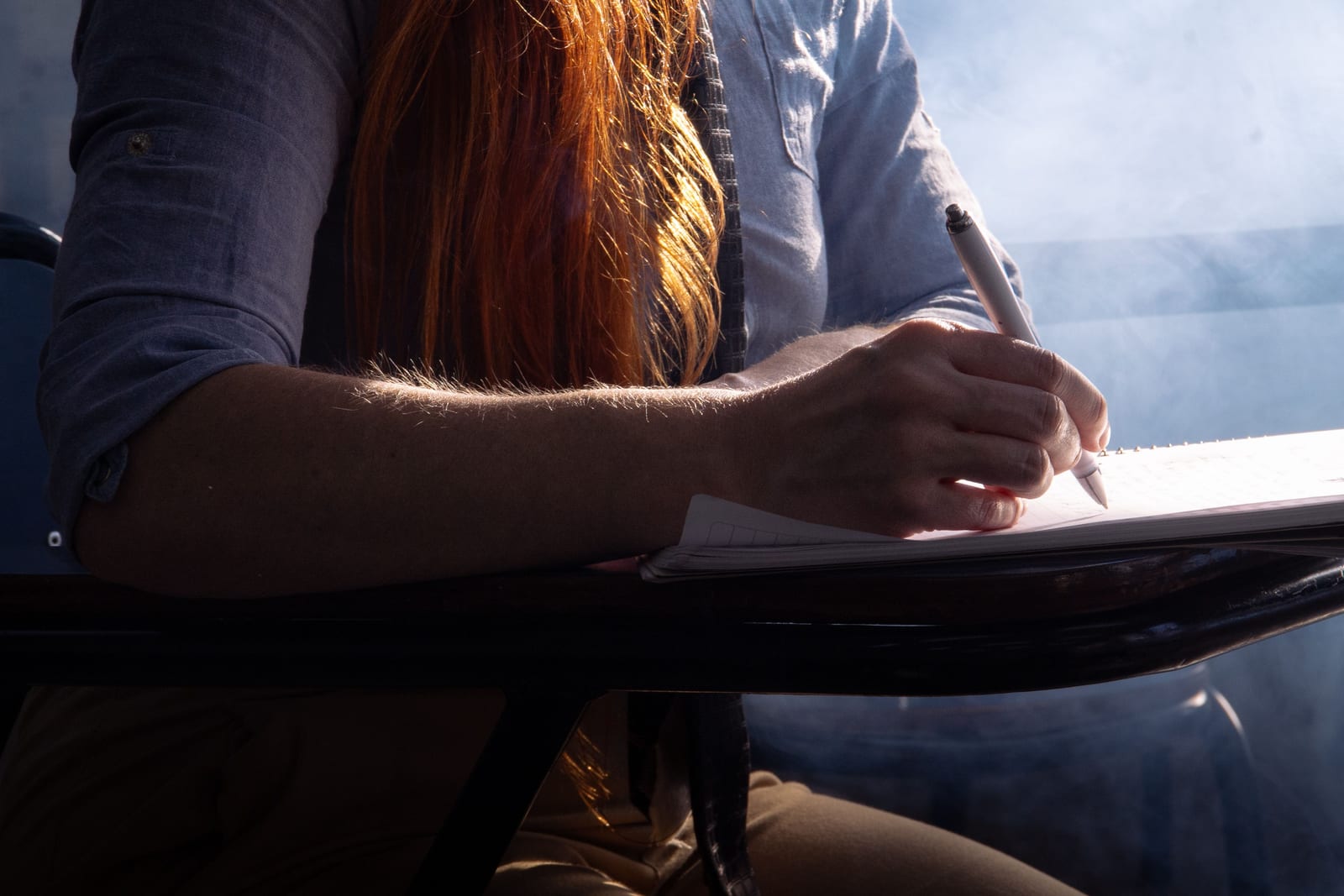 Person writing in a notebook in soft light