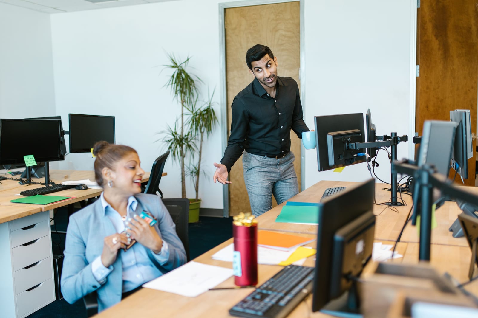 Two colleagues talking in an open office